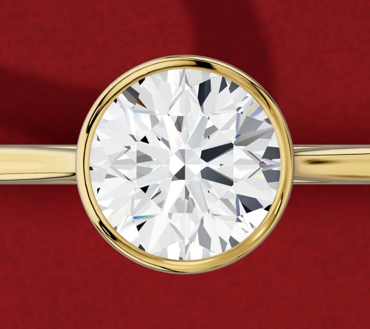 Round diamond bezel engagement ring, with a yellow gold rim around the whole stone, seen from above, by Lily Dia Jewellery