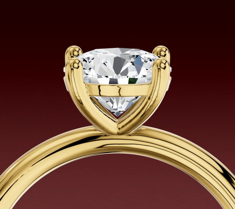 Side view of a round diamond four-claw setting, with upright claws and a gallery rail under the stone, by Lily Dia Jewellery