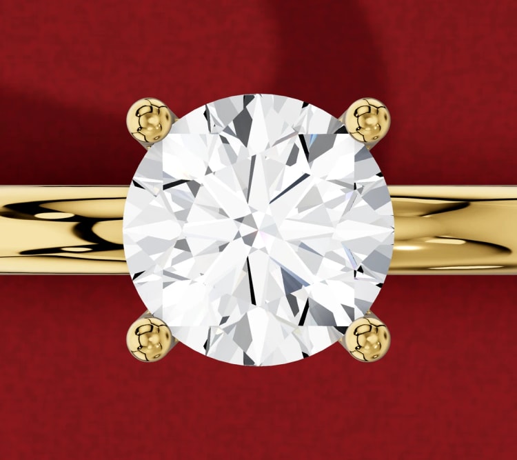 Round diamond four-claw prong engagement ring in yellow gold, seen from above, by Lily Dia Jewellery