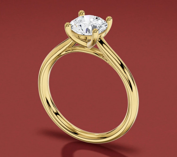 Cathedral round diamond solitaire engagement ring in yellow gold, seen at an angle, by Lily Dia Jewellery