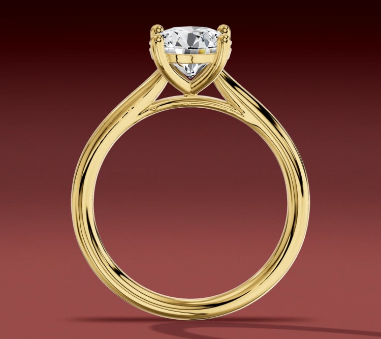 Cathedral solitaire seen through the finger opening, with the shoulders rising to the round diamond, by Lily Dia Jewellery