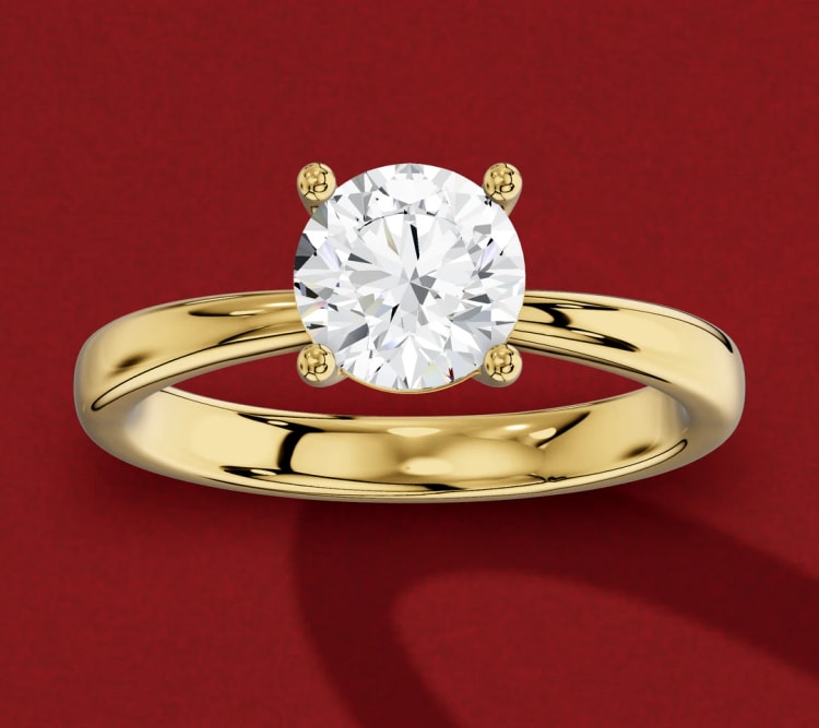 Pinched shank round diamond solitaire, with the yellow gold band narrowing as it reaches the head, by Lily Dia Jewellery