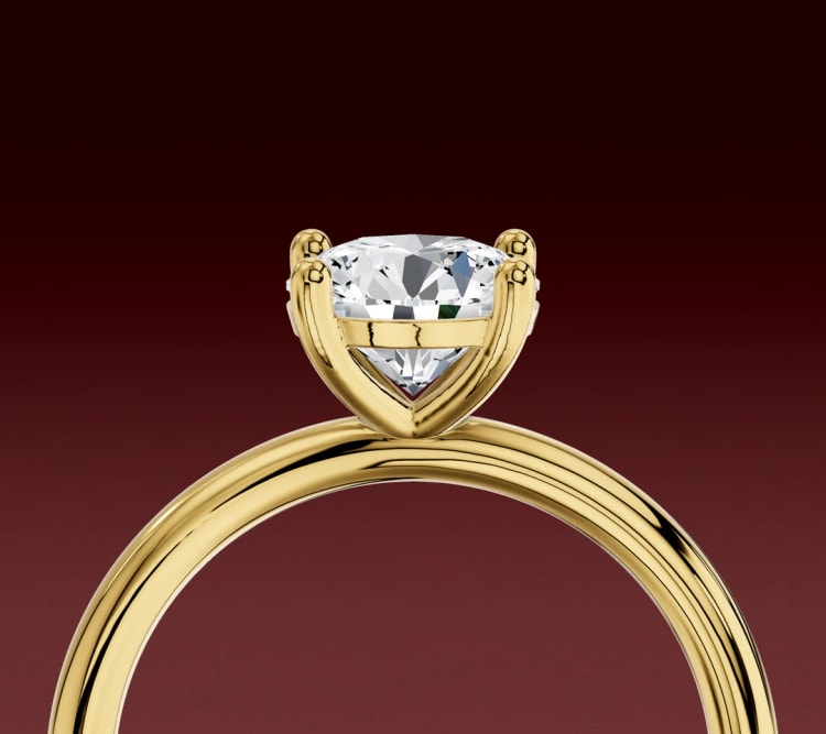 Side view of a round diamond solitaire engagement ring, showing the four claws and open basket, by Lily Dia Jewellery