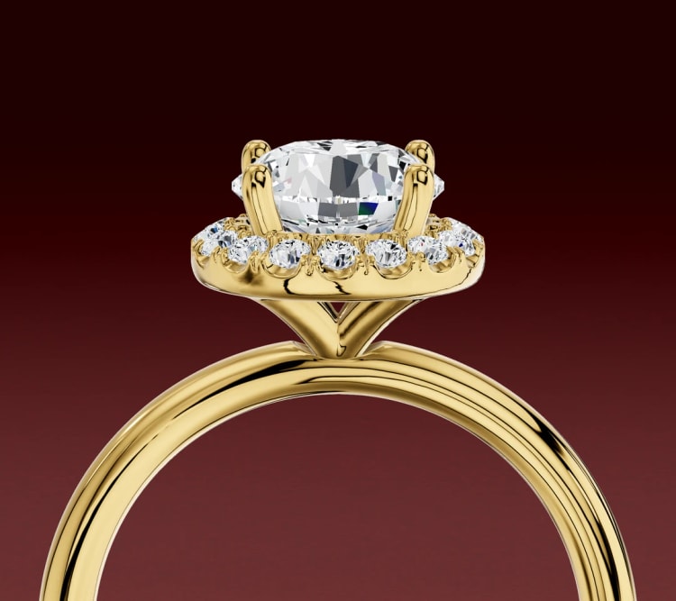 Side view of a halo engagement ring, with the halo of small diamonds around the round centre stone, by Lily Dia Jewellery