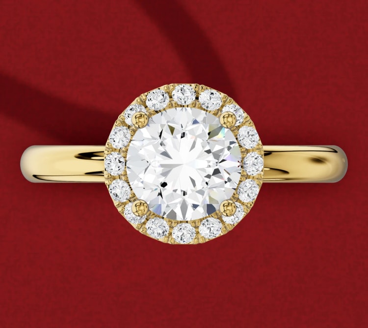 Halo engagement ring with a round diamond framed by small diamonds in yellow gold, seen from above, by Lily Dia Jewellery