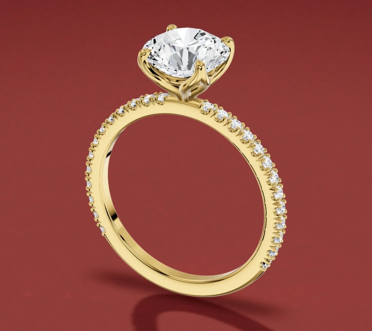 Tulip setting engagement ring with a round diamond on a yellow gold pavé band, seen at an angle, by Lily Dia Jewellery