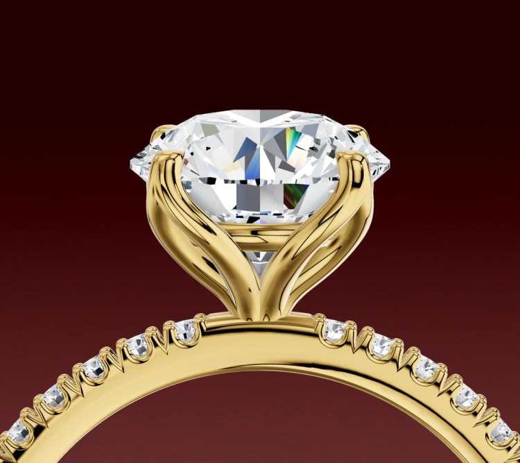 Side view of a tulip setting engagement ring, with petal-shaped yellow gold claws beneath a round diamond and a pavé band, by Lily Dia Jewellery