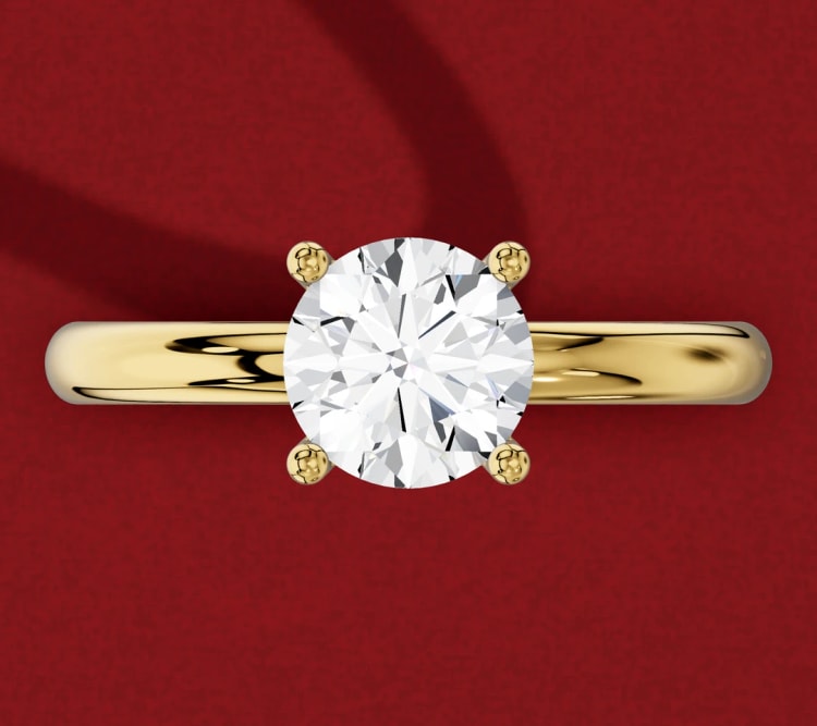 Straight shank round diamond solitaire with four claws on a plain yellow gold band, seen from above, by Lily Dia Jewellery