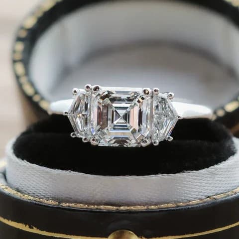 An asscher cut diamond three-stone engagement ring with cadillac cut side stones, an asscher cut diamond shape education guide by Lily Dia Jewellery