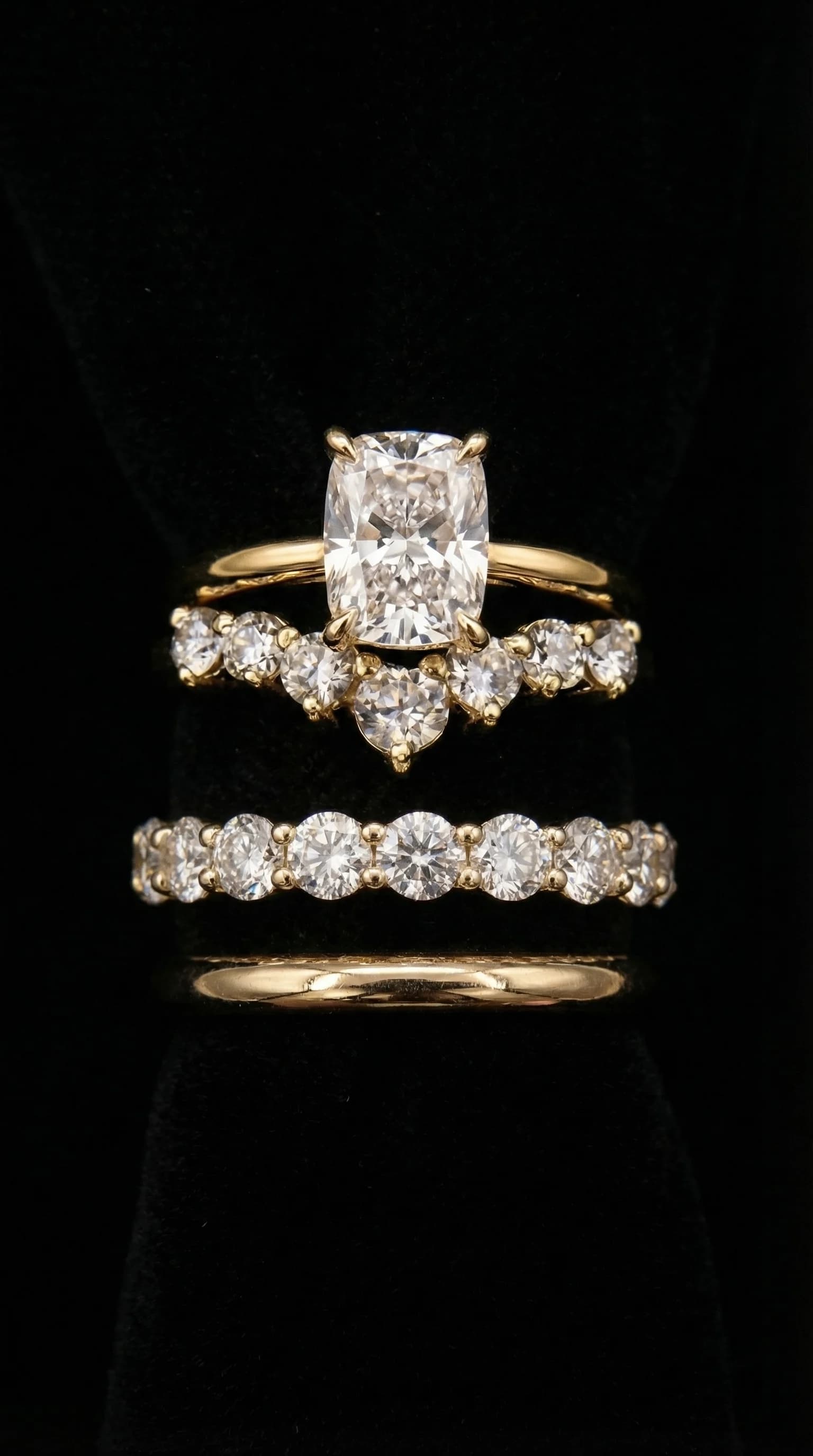 A cushion cut diamond solitaire engagement ring stacked with a curved diamond band and a plain wedding band in yellow gold, a cushion cut diamond shape education guide by Lily Dia Jewellery