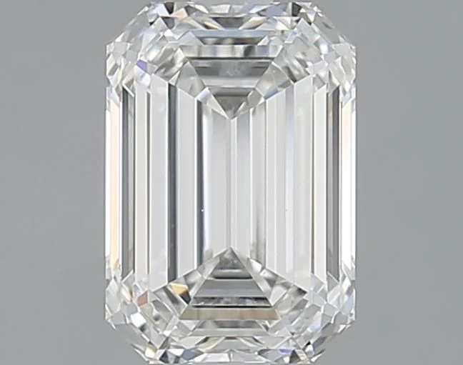 A loose emerald cut diamond shown close up, its long parallel step facets and clipped corners creating broad flashes of light, an emerald cut diamond shape education guide by Lily Dia Jewellery