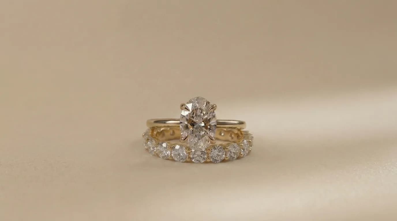 An oval cut diamond solitaire engagement ring paired with a diamond eternity wedding band in yellow gold, an oval diamond shape education guide by Lily Dia Jewellery
