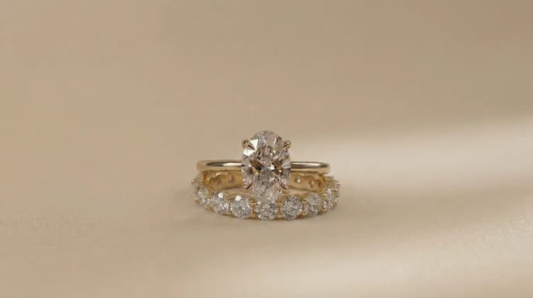 Oval cut diamond solitaire engagement ring worn with a wedding band by Lily Dia Jewellery