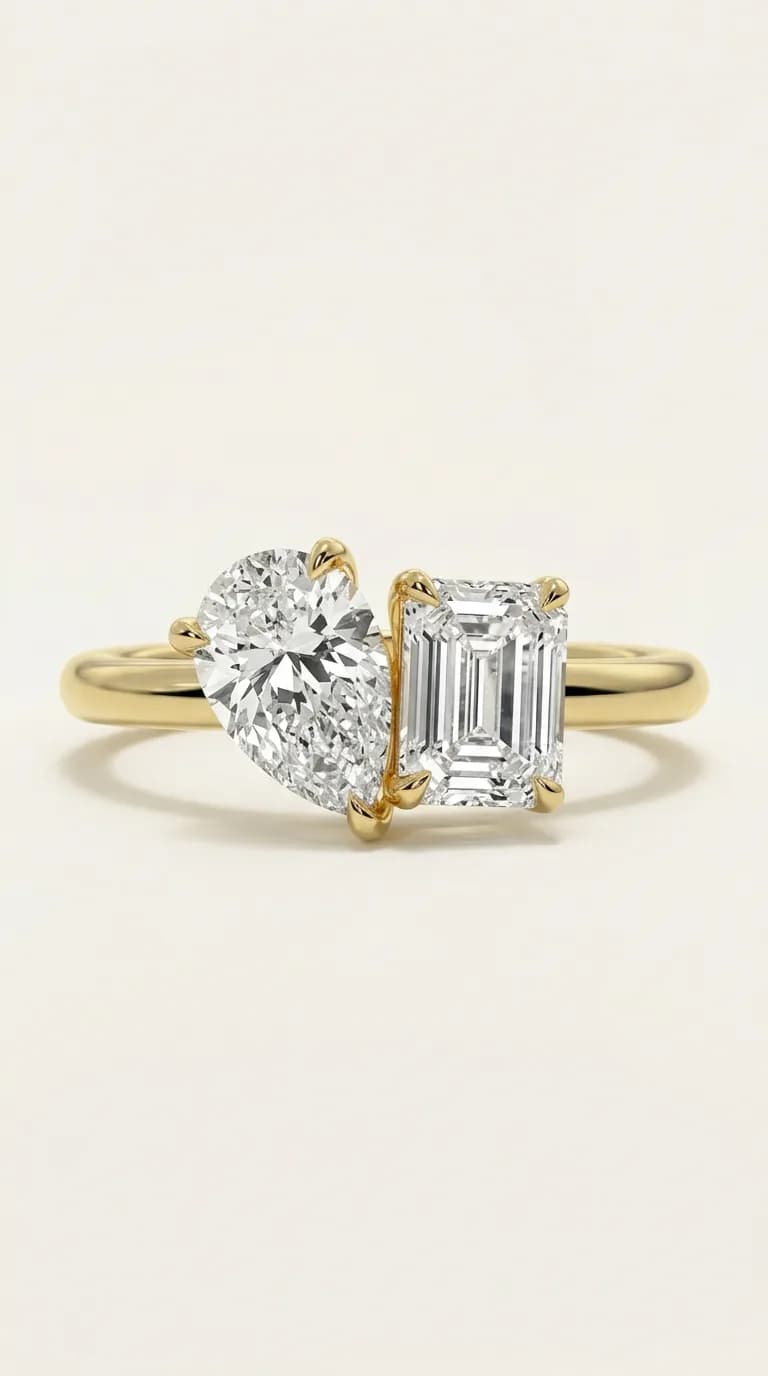 A pear cut diamond set beside an emerald cut diamond on a yellow gold toi et moi engagement ring, a toi et moi engagement ring style guide by Lily Dia Jewellery