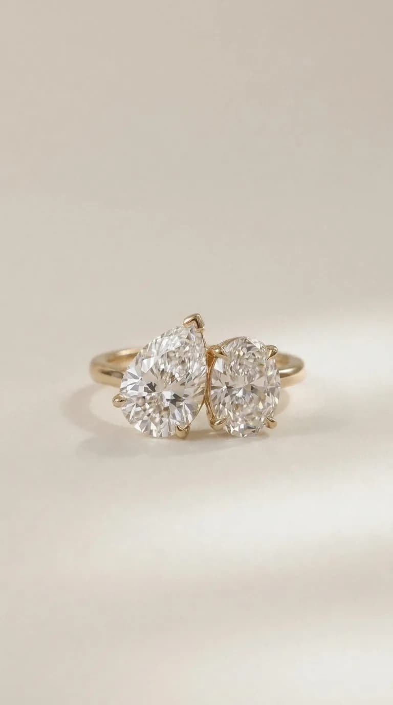 A pear cut diamond set beside an oval diamond on a yellow gold toi et moi engagement ring, a toi et moi engagement ring style guide by Lily Dia Jewellery