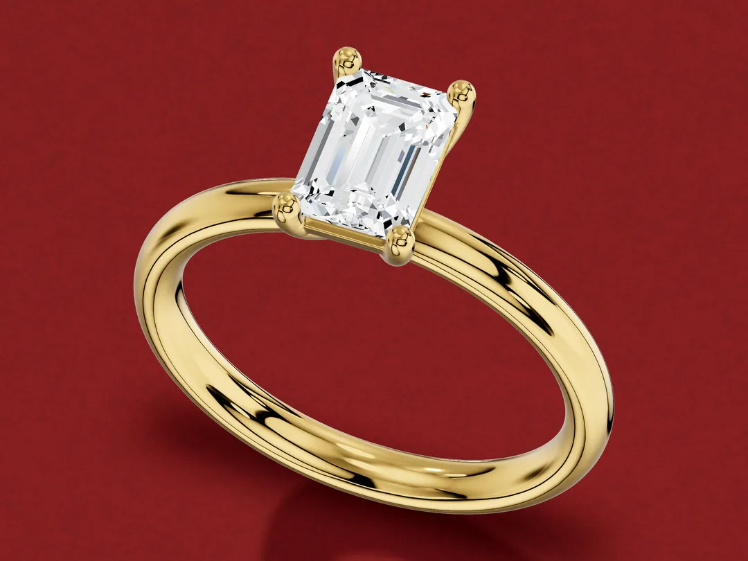 3D render of an emerald-cut diamond in a four-claw yellow gold solitaire ring.