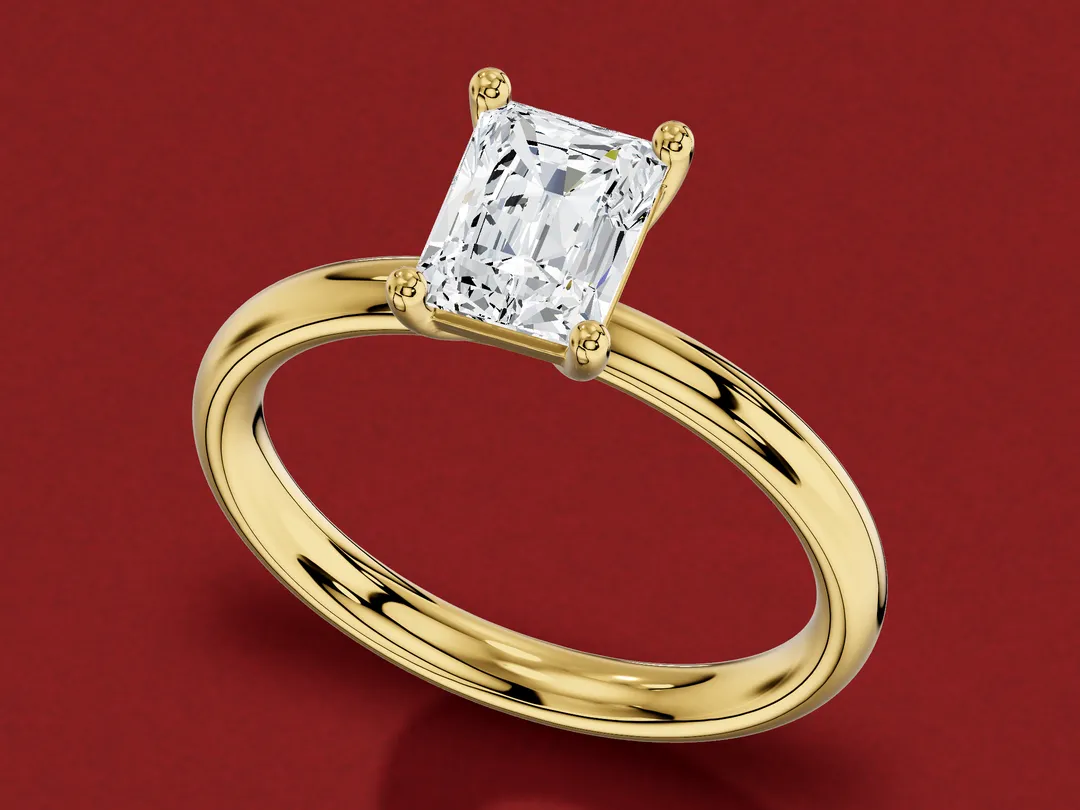 3D render of a rectangular radiant-cut diamond in a four-claw yellow gold solitaire ring.
