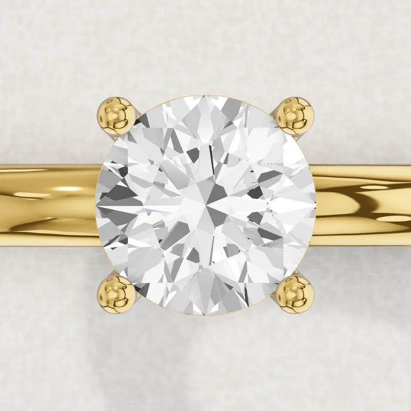 3D render of a 1 carat round diamond held by four yellow gold prongs, seen from above
