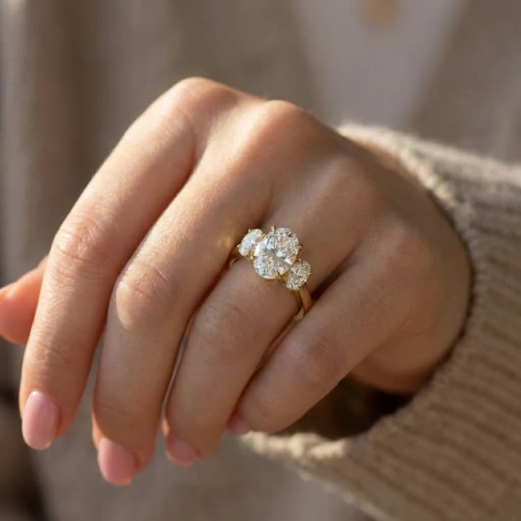 Oval three stone engagement ring on hand by Lily Dia Jewellery
