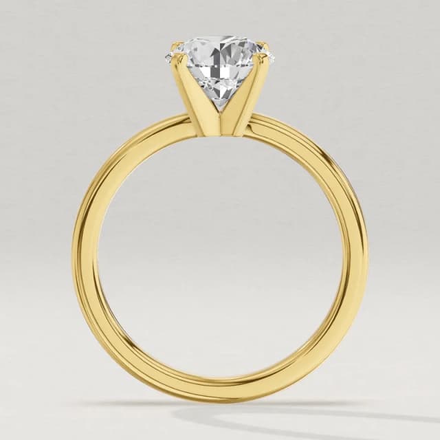 Profile view through the finger hole of the same yellow gold four-claw solitaire with a 1.5 carat round diamond, a 3D render at the same scale as the 1, 2 and 3 carat rings beside it