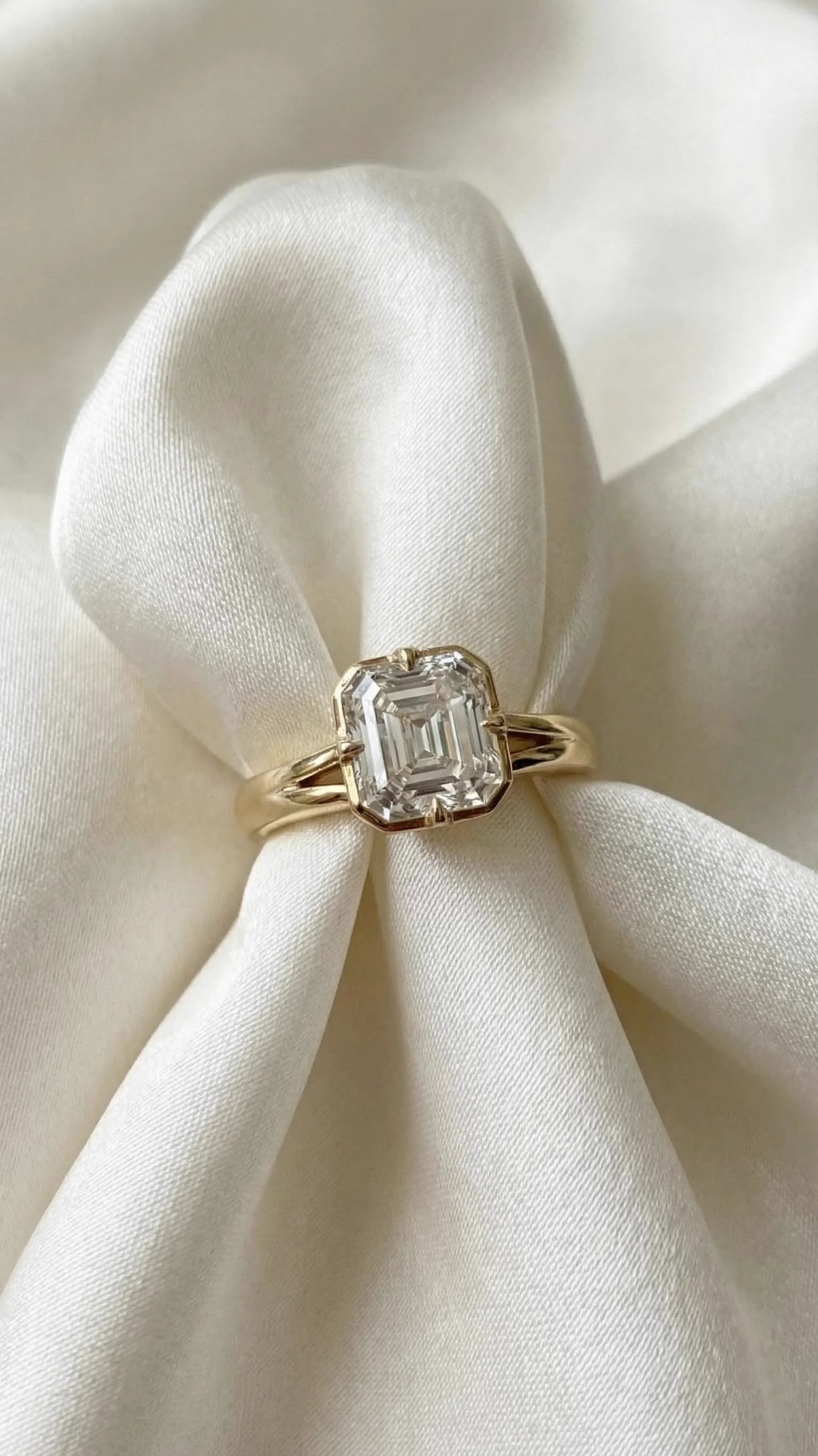 Asscher-cut diamond engagement ring in yellow gold on ivory satin