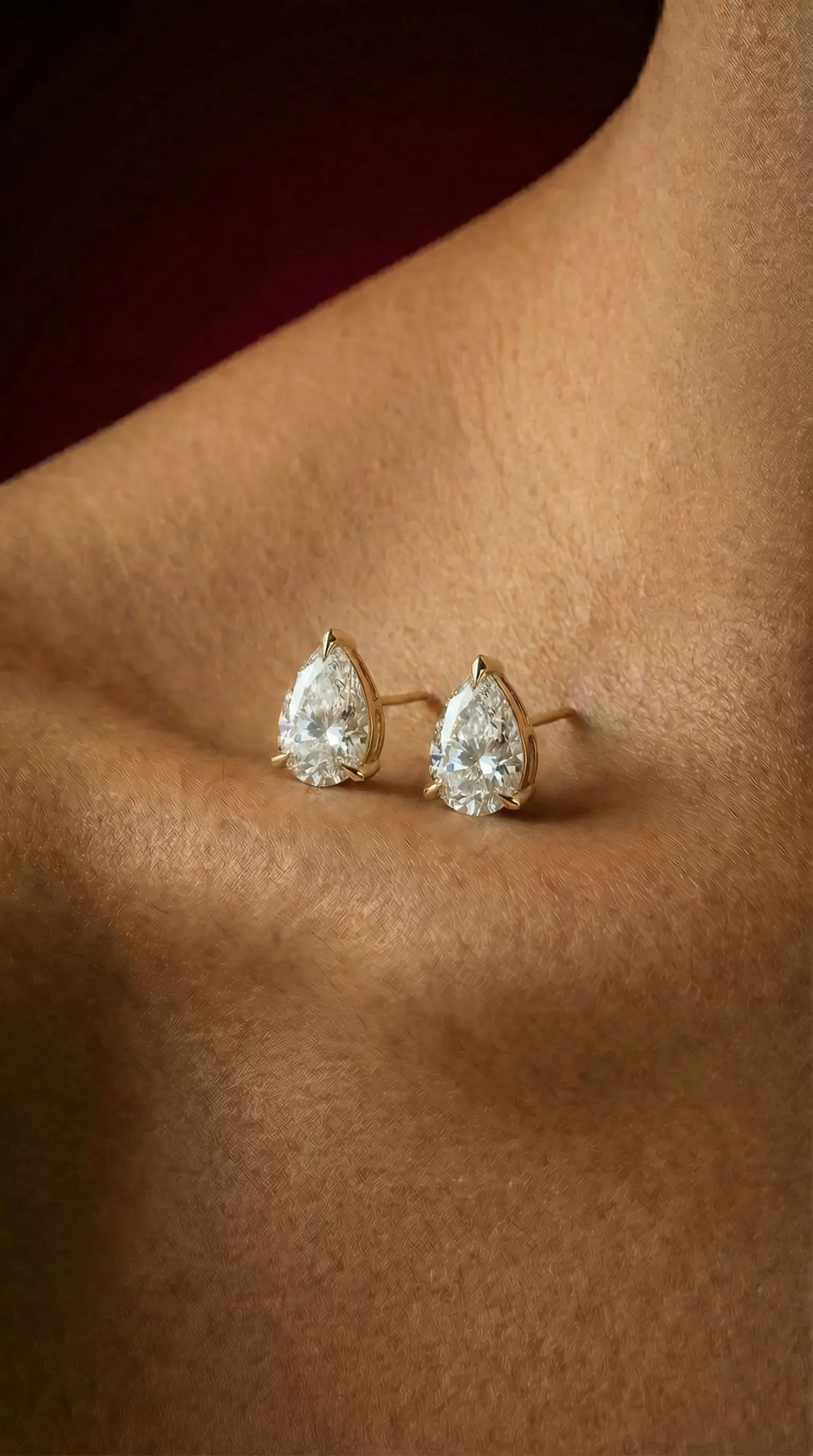 Close-up of model wearing a Lily Dia Jewellery Marquise cut diamond engagement ring on a yellow gold band with matching marquise diamond stud earrings.