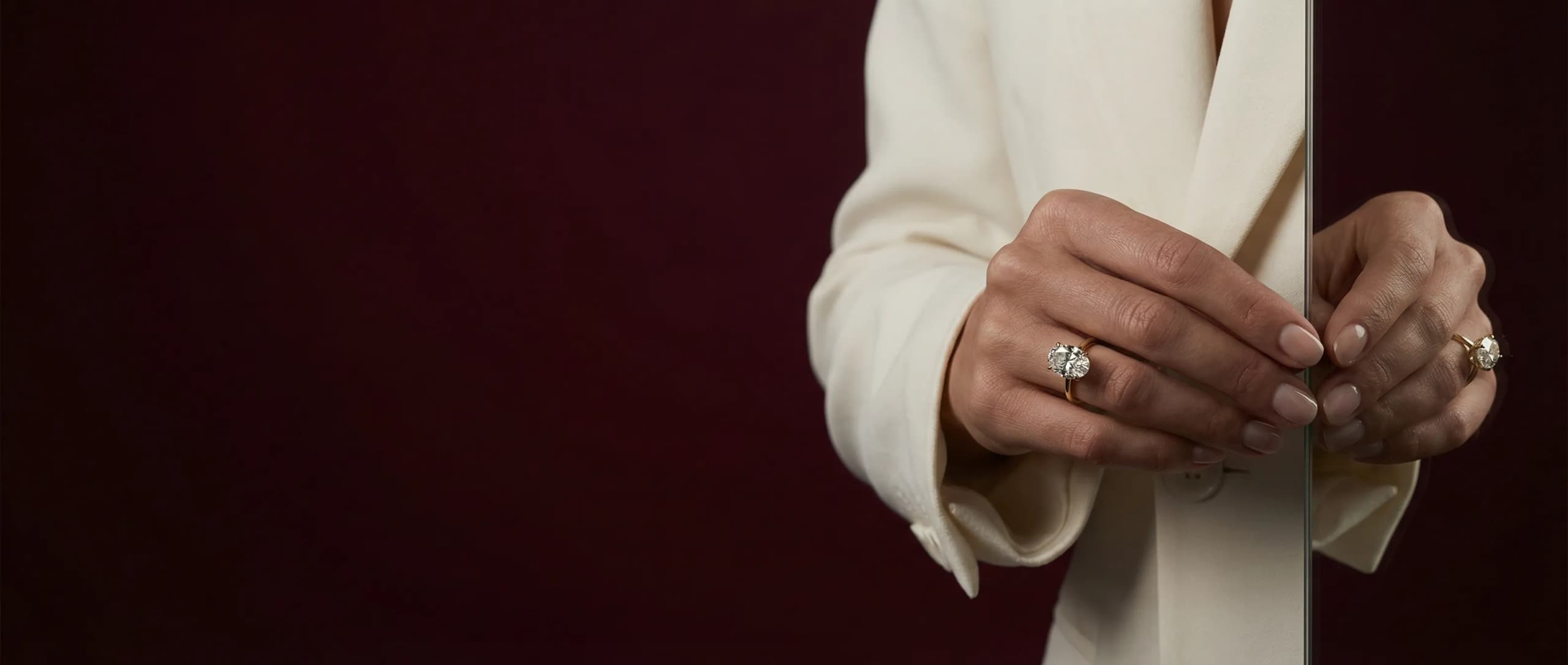 Model wearing an oval lab-grown diamond solitaire engagement ring in yellow gold by LILY DIA Jewellery