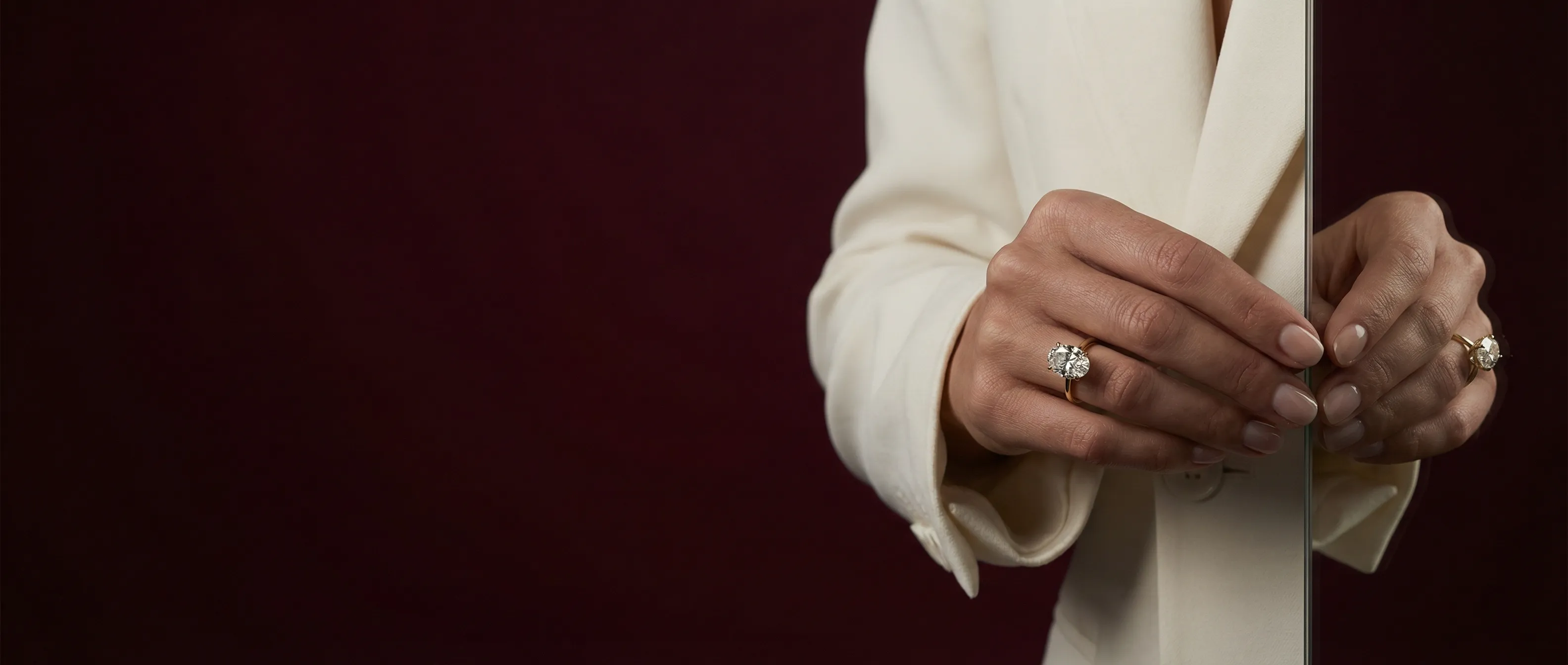 Model wearing an oval lab-grown diamond solitaire engagement ring in yellow gold by LILY DIA Jewellery